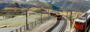 Red Gornergrat Railway trains climbing the Swiss Alps near Zermatt, Switzerland.