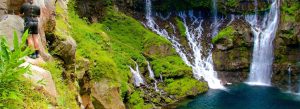 Adventure canyoning near Grand Galet Falls in Reunion Island surrounded by lush tropical vegetation, cascading waterfalls, and volcanic rock cliffs.