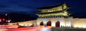 Night view of Gwanghwamun Gate illuminated with traditional Korean architecture and light trails from passing traffic