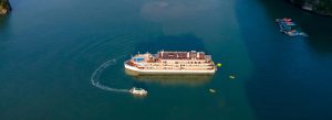 Luxury cruise ship sailing through the deep blue waters of Hạ Long Bay during a scenic journey from Halong to Hanoi