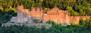 Panoramic view of Heidelberg Castle surrounded by forested hills in Heidelberg, Germany.