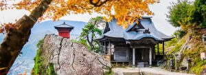 Hōjusan Risshakuji Temple surrounded by autumn foliage and mountain rocks in Yamadera, Japan.