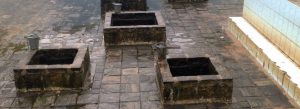 Ancient stone wells at Kanniya Hot Springs in Trincomalee, Sri Lanka surrounded by a historic paved courtyard