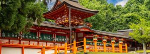 Kasuga Shrine in Nara surrounded by lush green forest and traditional Japanese architecture.