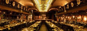 Elegant interior of La Ventana Tango Show in Buenos Aires with candlelit dining tables, brick architecture, and a stage for traditional Argentine tango performances.