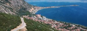 Panoramic view of Lake Eğirdir in Turkey with mountain scenery, coastal town, and crystal blue water.