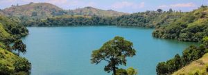 Scenic view of Lake Nyinambuga surrounded by green hills and forests in western Uganda.
