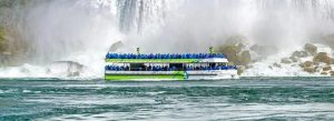 Maid of the Mist boat tour approaching Niagara Falls surrounded by mist and cascading waterfalls