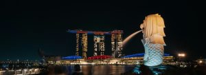 Merlion statue fountain with Marina Bay Sands illuminated at night in Singapore skyline
