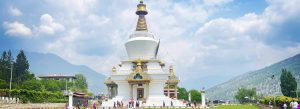 National Memorial Chorten in Thimphu, Bhutan surrounded by mountains and landscaped gardens under a blue sky.