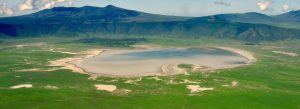 Aerial view of Ngorongoro Crater in Tanzania featuring lush green plains and crater lake