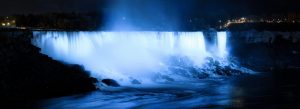 Night view of Niagara Falls illuminated in blue lights near Buffalo
