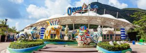 Main entrance of Ocean Park Hong Kong featuring colorful marine-themed sculptures and scenic mountain backdrop.
