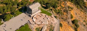 Aerial view of Garni Temple surrounded by rocky hills and green landscape