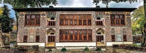 Front view of the Palace of Shaki Khans in Azerbaijan featuring colorful stained glass windows, intricate geometric patterns, and traditional Persian-inspired architecture.