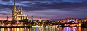 Panoramic night view of Cologne Cathedral and Hohenzollern Bridge in Cologne, Germany