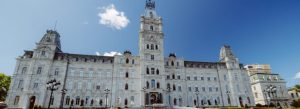 Historic Parliament Building in Quebec City, Canada, with its grand white facade, central clock tower, and clear blue sky.