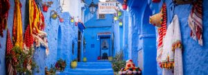 Colorful blue-painted alleyway with traditional Moroccan décor in Chefchaouen, Morocco.