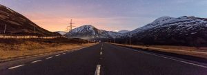 Scenic road through the snow-capped mountains near Pitlochry in the Scottish Highlands at dusk.