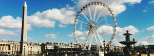 Place de la Concorde in Paris featuring the Luxor Obelisk, Ferris wheel, and historic French architecture under a bright blue sky.