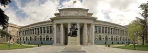 Front view of the Prado Museum in Madrid, Spain, featuring neoclassical architecture and the statue of Velázquez.