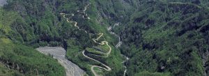 Winding mountain road along the Route de Cilaos surrounded by steep cliffs, lush vegetation, and dramatic volcanic landscapes.
