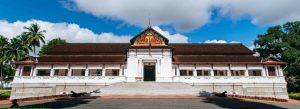 Front view of Royal Palace Museum with traditional Lao architecture under a bright blue sky
