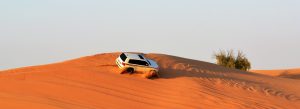 4x4 SUV dune bashing across golden sand dunes in Dubai desert safari adventure