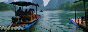 Bamboo raft river cruise with tourists sailing past karst mountains in Guilin China