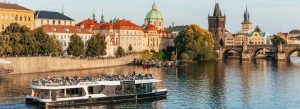 Scenic river cruise on the Vltava River with Charles Bridge and Prague skyline in Czech Republic
