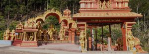 Colorful Seetha Amman Temple in Nuwara Eliya, Sri Lanka with ornate Hindu statues and mountain surroundings.