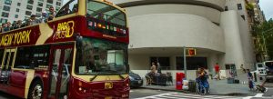 Open-top Big Bus New York sightseeing tour bus passing the Solomon R. Guggenheim Museum in Manhattan, New York City