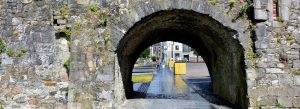 Stone archway of the Spanish Arch in Galway City, Ireland, with a pedestrian walkway passing beneath the historic medieval structure.