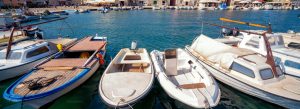 Small boats docked along the waterfront in Stari Grad on Hvar Island, Croatia, under sunny Mediterranean skies.