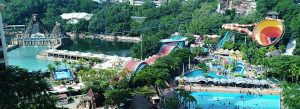 Panoramic view of Sunway Lagoon theme park in Malaysia featuring water slides, wave pools, tropical greenery, and adventure attractions.