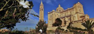 Ta’ Pinu Sanctuary in Gozo surrounded by gardens under a blue Mediterranean sky.