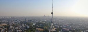 Tashkent TV Tower rising above the city skyline in Tashkent, Uzbekistan during a hazy sunset aerial view