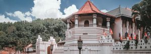Temple of the Sacred Tooth Relic in Kandy, Sri Lanka surrounded by lush hills and traditional Sinhalese architecture.