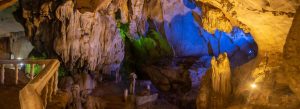 Interior view of Tham Jang Cave with dramatic limestone formations and colorful lighting in Vang Vieng