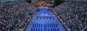Crowds watching the Royal Edinburgh Military Tattoo performance at Edinburgh Castle in Scotland with military bands marching in formation.