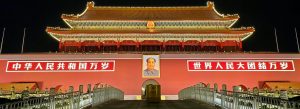 Tiananmen Gate illuminated at night in Beijing, China with traditional Chinese architecture and Mao Zedong portrait