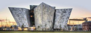 Modern Titanic Belfast building in the Titanic Quarter with striking silver architecture at sunset.