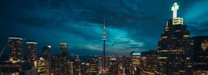 Toronto skyline at night with illuminated CN Tower and downtown skyscrapers in Ontario, Canada.