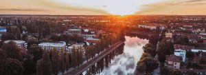 Aerial sunset view of the town of Gyor with rivers, tree-lined streets, and residential buildings in Hungary.