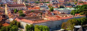 Panoramic aerial view of Vilnius, Lithuania featuring historic churches, red-roofed buildings, and the charming Old Town skyline.