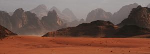 Wadi Rum desert with red sand dunes and dramatic rock formations in Jordan
