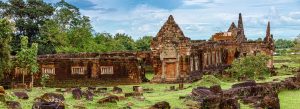 Ancient stone temple ruins at Wat Phu surrounded by lush greenery in southern Laos