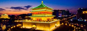 Illuminated Bell Tower at night in Xi’an China with city lights and traffic