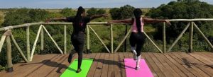 Women practicing yoga outdoors overlooking nature in Masai Mara, Kenya