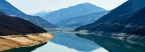 Panoramic view of Zhinvali Reservoir with blue water and mountain landscapes in Georgia.